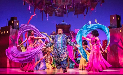07 Genie (Trevor Dion Nicholas) in market surrounded by scarfs - photo by Johan Persson © Disney